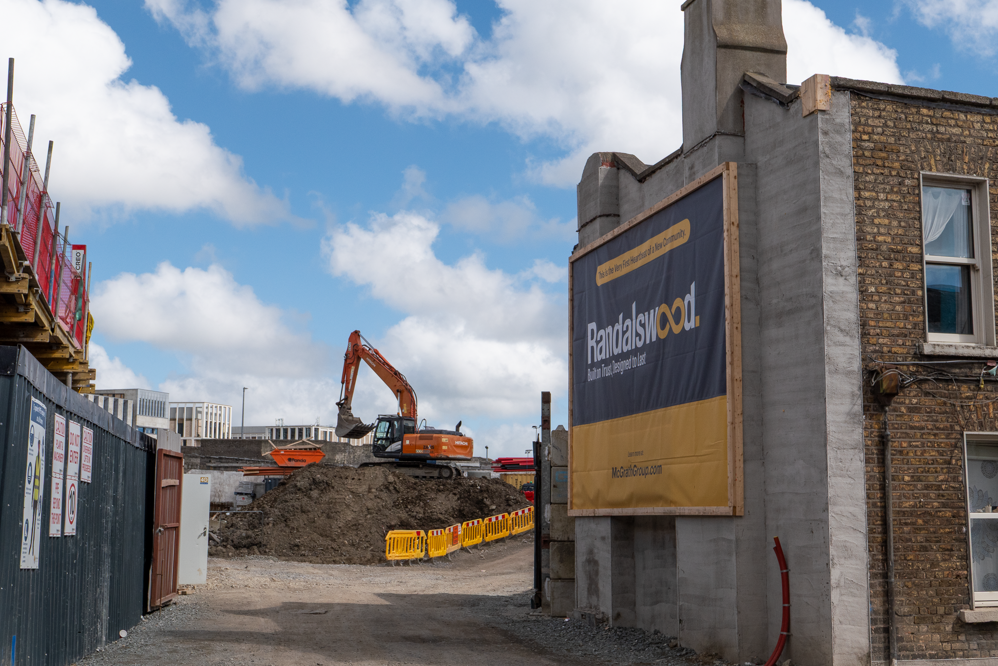 Cleared site, formerly 24-25 Prussia Street. The Randalswood billboard, reading 'this is the very first heartbeat of a new community,' is affixed to what was the exterior wall of 23 Prussia Street; which was occupied and ran as a social centre by squatters' group That Social Centre in 2021.