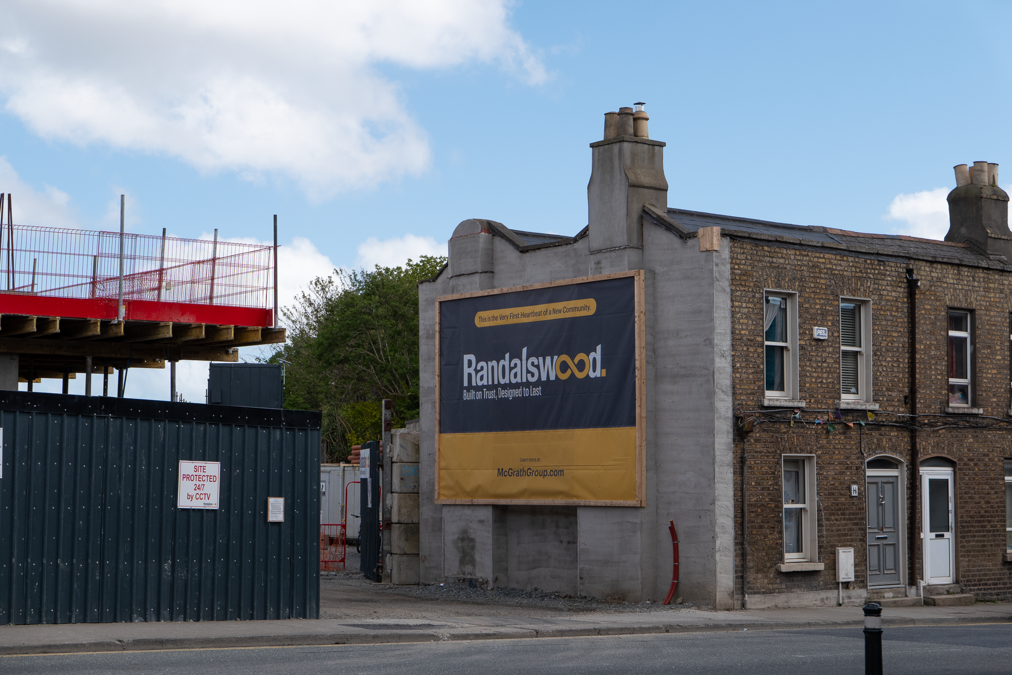 Cleared site, formerly 24-25 Prussia Street. The Randalswood billboard, reading 'this is the very first heartbeat of a new community,' is affixed to what was the exterior wall of 23 Prussia Street; which was occupied and ran as a social centre by squatters' group That Social Centre in 2021.